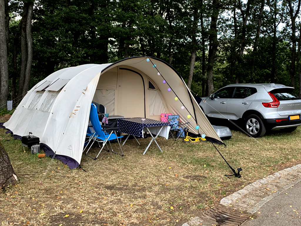 Auto naast de tent op de camping